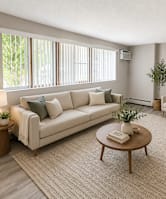 A living room with a couch, a chair, a coffee table, and a television.