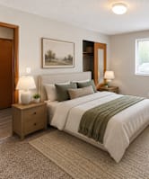A bedroom with a large bed, a nightstand with a lamp, and a small tree.