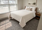 Thumbnail 9 of 10 - A bedroom with a large bed and a painting on the wall.