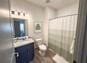 Thumbnail 8 of 10 - A bathroom with a toilet, sink, and shower.