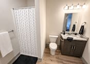 Thumbnail 10 of 10 - A bathroom with a toilet, sink, and shower.