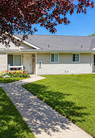A house with a grey roof and a white fence.