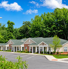 A row of houses with green roofs and white columns.