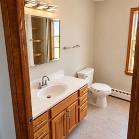 A bathroom with a white sink and a white toilet.