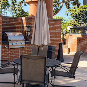 A patio with a table, chairs, and an umbrella.