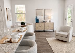 A living room with a white couch, a wooden cabinet, and a television.