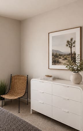 A bedroom with a bed, a chair, a dresser, and a painting on the wall.