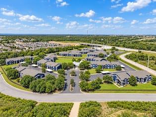 A bird's eye view of a residential complex with multiple houses and a road.