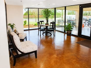 A living room with a black couch, a coffee table, and a dining table with chairs.