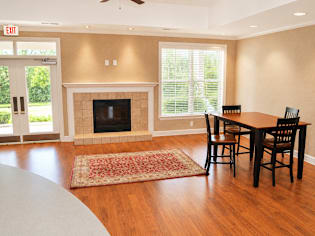 A living room with a fireplace and a dining table.