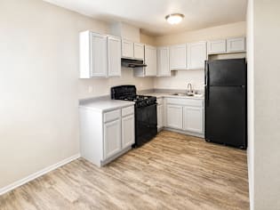 A kitchen with black appliances and white cabinets.