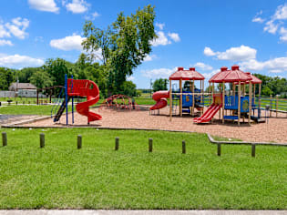 A playground with a red slide and a blue slide.
