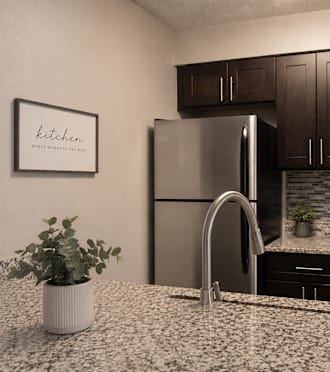 A kitchen with a refrigerator, microwave, and oven.