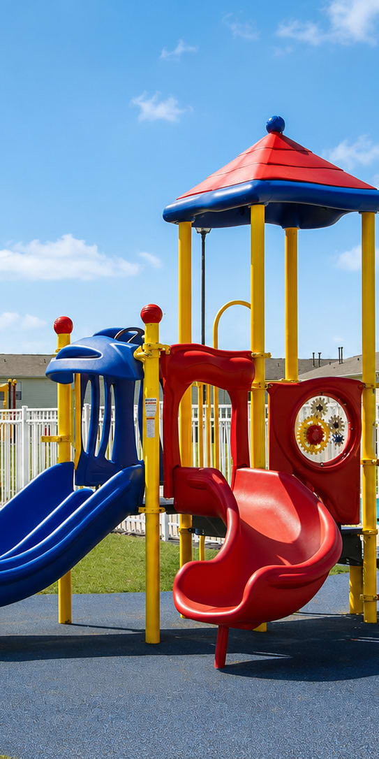 A playground with a red slide and a blue slide.