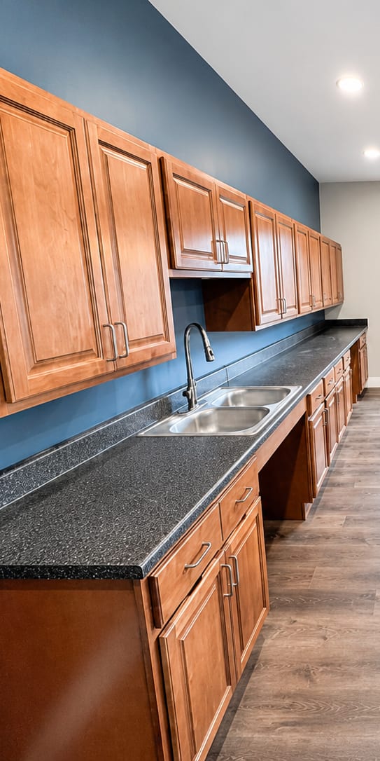 A kitchen with wooden cabinets and a black countertop.