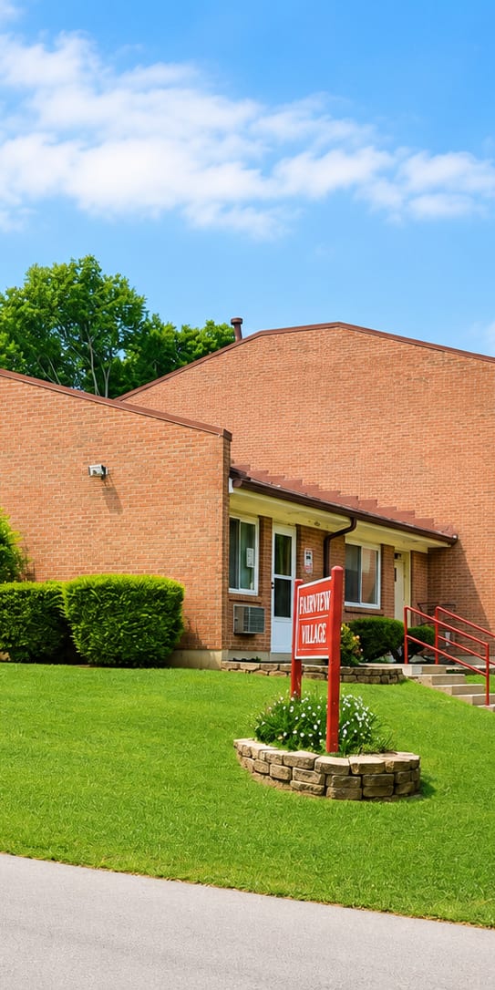 A red brick building with a red gate in front.