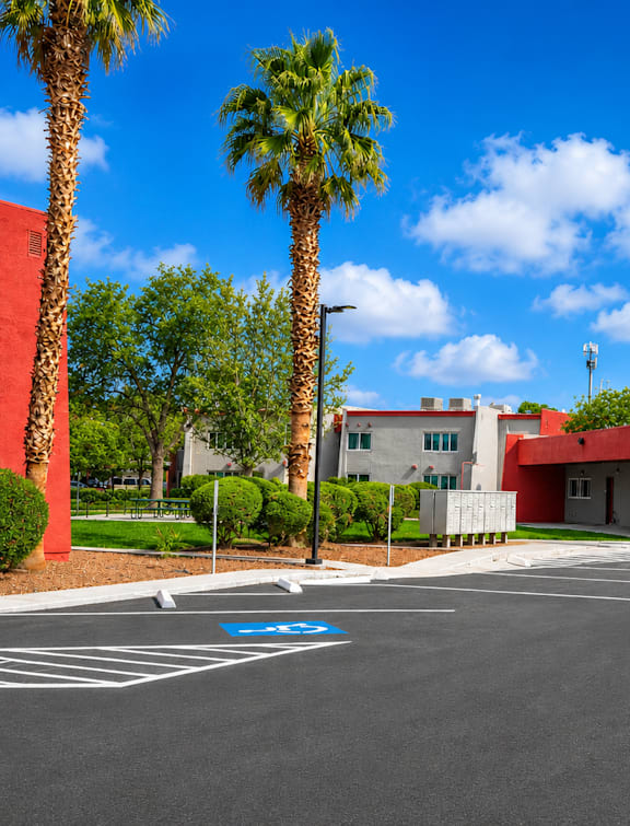 Palm trees in front of a building with a red wall.