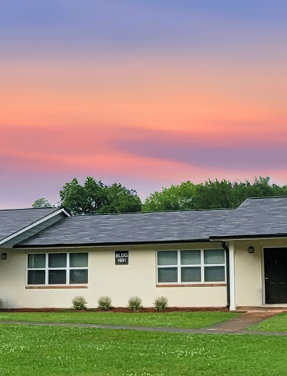 A small house with a green lawn in front.