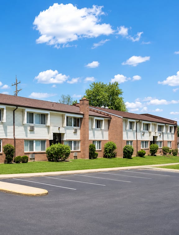 Apartment building with a parking lot in front.