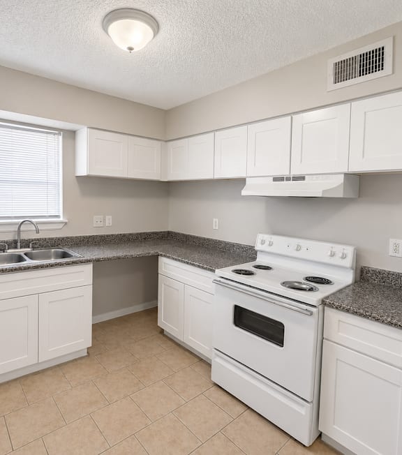 A kitchen with white appliances and cabinets.