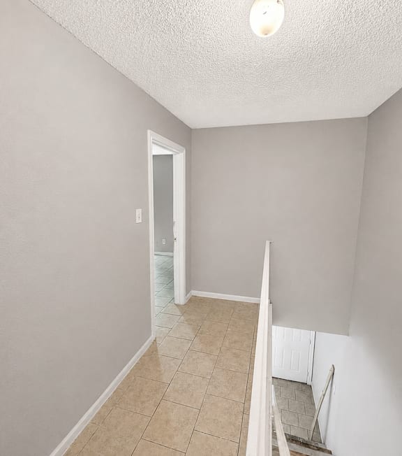 A room with a tiled floor and a doorway leading to another room.