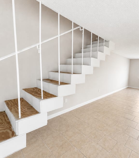 A white staircase with wooden steps and handrails.