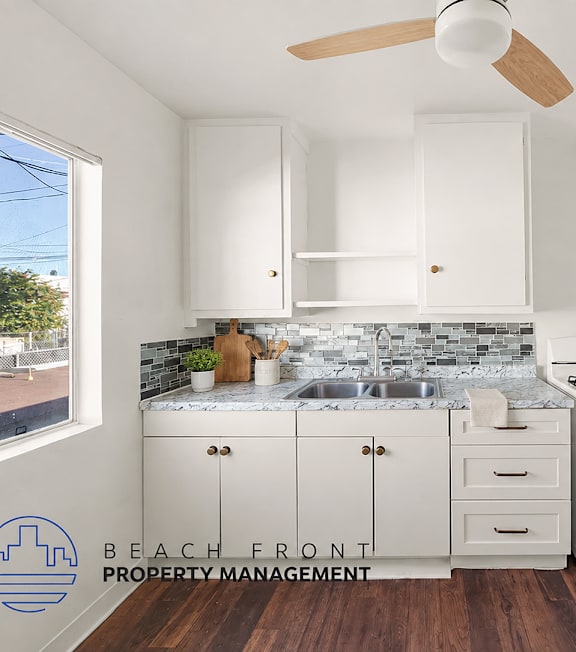 A well-lit, modern kitchen and living room with a dining area.