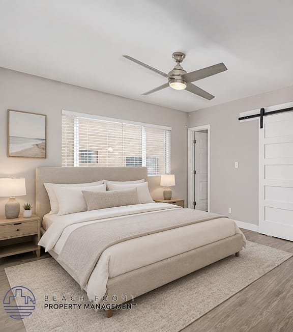 A well-lit bedroom with a large bed and a painting on the wall.