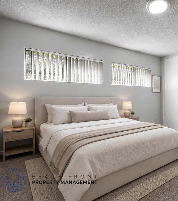 A well-lit bedroom with a large bed and a painting on the wall.