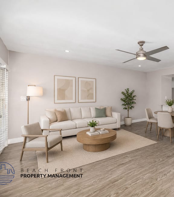 A living room with a white couch, a coffee table, and a dining table with chairs.