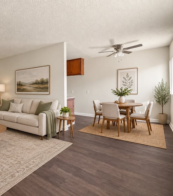 A living room with a white couch, a wooden coffee table, and a painting on the wall.