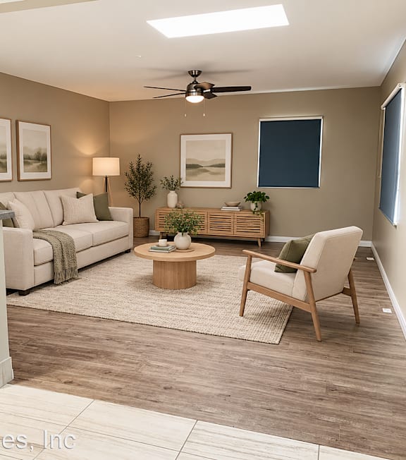 A living room with a white couch, a wooden coffee table, and a ceiling fan.