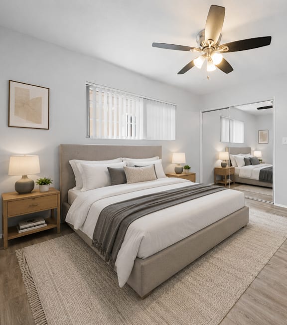 A bedroom with a large bed and a ceiling fan.