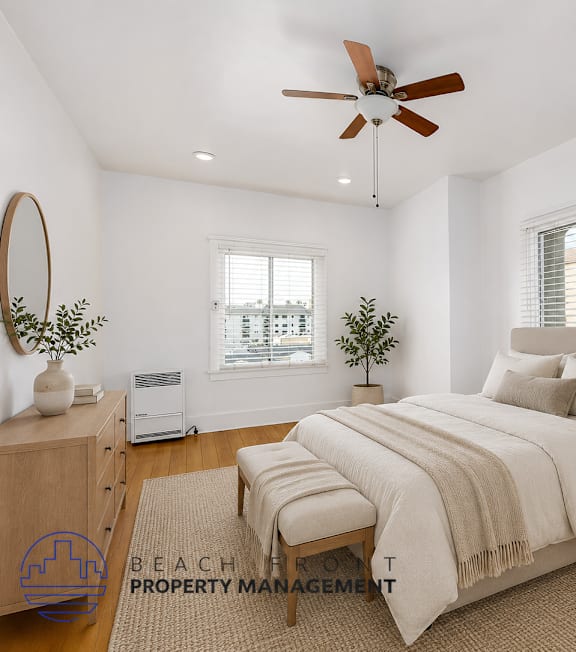 A room with a ceiling fan and wooden floors.