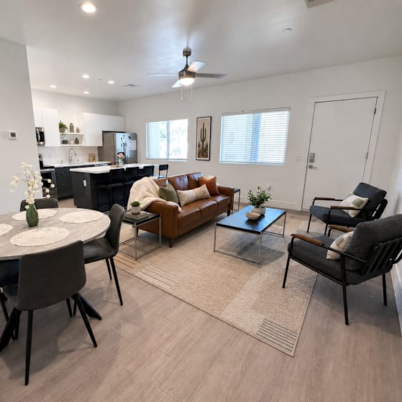 A modern living room with a dining table and chairs.