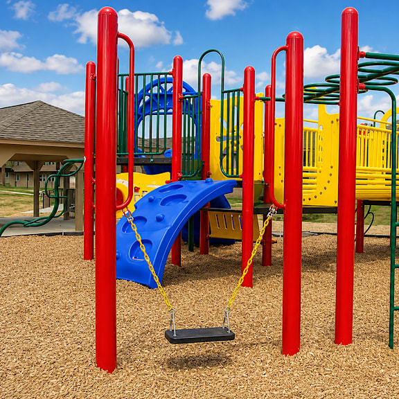A playground with a blue slide and red and yellow play equipment.