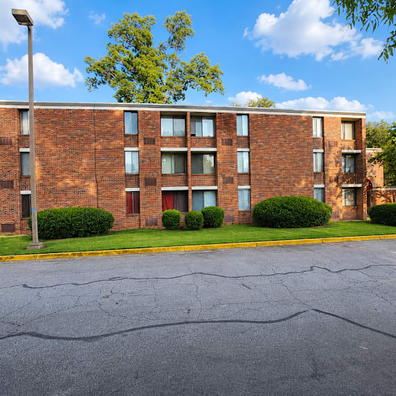 A large brick building with a parking lot in front.
