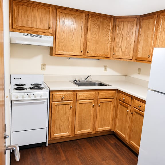 A kitchen with wooden cabinets and a white refrigerator.