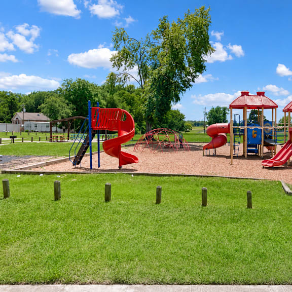 A playground with a red slide and a blue slide.