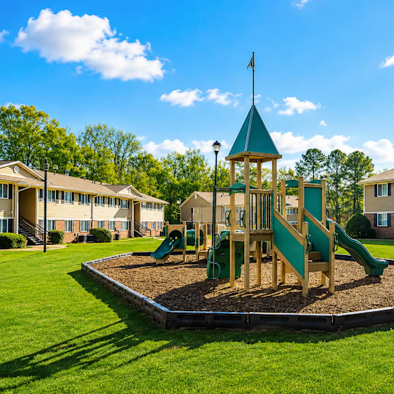 A playground with a green slide and a wooden structure with a flag on top.