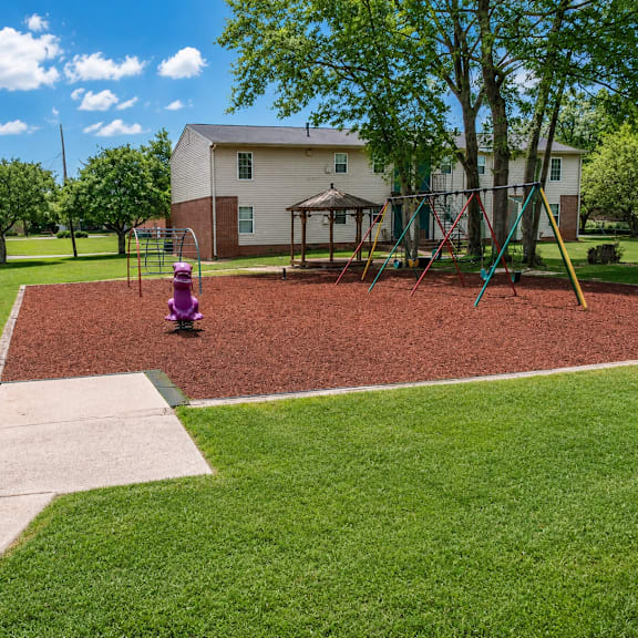A playground with a red surface and a purple slide.