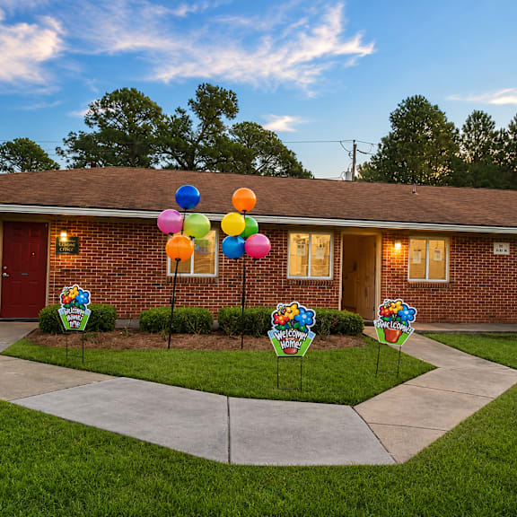 A house with a driveway and a sign that says "Welcome to Sunshine Elementary School".