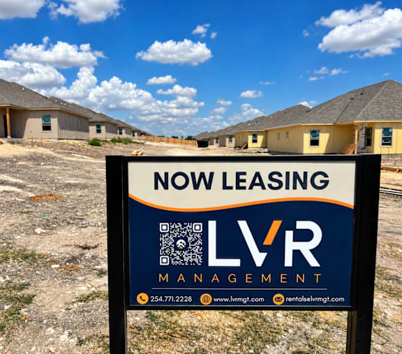 A sign for LVR Management advertises a new leasing opportunity.