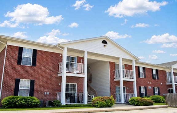 A row of townhouses with a green lawn in front.