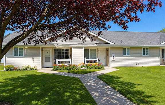 A house with a grey roof and a white fence.