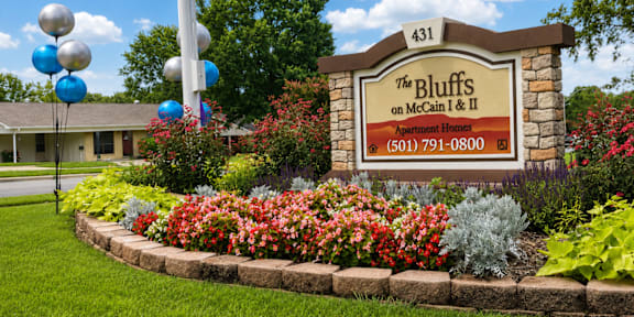 A sign for The Bluffs on McCain & II Apartment Homes with a phone number on it.