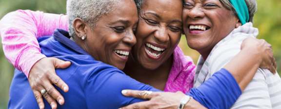 Three women hugging each other in a close embrace.