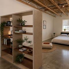 A bedroom with a bed, a shelf, and a rug.