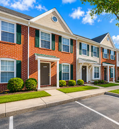 A row of townhouses with green bushes in front.