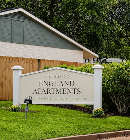 A sign for England Apartments is in front of a building.